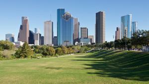 a green field with a city skyline in the background at Urban Oasis Your Perfect Getaway in the Heart of Downtown! in Houston