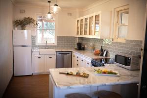 a kitchen with white appliances and a white refrigerator at Avoca House - Gorgeous Federation Home in Mudgee