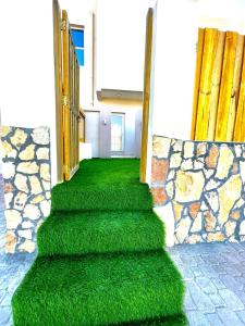 a stairway with green grass and a stone wall at Al Asala Resort in Al Ruwis