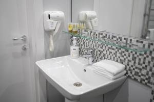 a bathroom with a sink and a phone on the wall at Koghbatsi Aparthotel in Yerevan