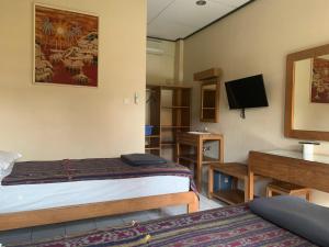 Camera con letto, scrivania e TV. di Prambanan Guesthouse a Yogyakarta Altre 17 foto