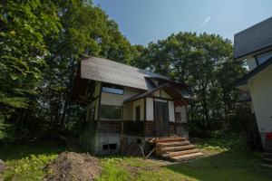 a small house sitting on top of a yard at Kudo's Lodge in Hakuba