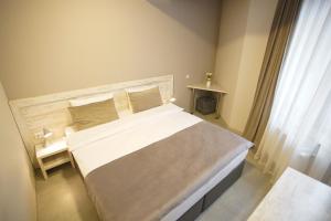 a bedroom with a large bed and a window at Koghbatsi Aparthotel in Yerevan