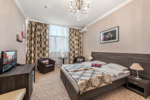 Un dormitorio con una cama grande y una lámpara de araña. en Seven Inn Boutique Hotel, en Astana