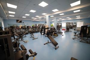 a gym with a lot of treadmills and machines at Chagala Hotel Aksai in Aksay