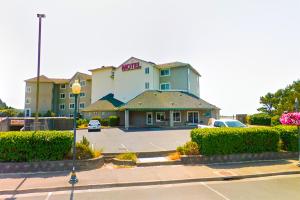 a hotel with a parking lot in front of it at Siletz Bay Beachfront Hotel by OYO Lincoln City in Lincoln City