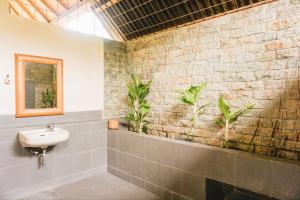 a bathroom with a sink and plants on the wall at Roemah Nelayan in Montongbuwoh +90 photos