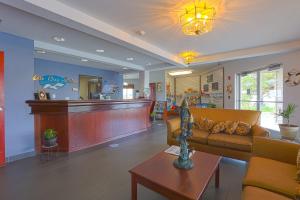a waiting room with a couch and a bar at Siletz Bay Beachfront Hotel by OYO Lincoln City in Lincoln City