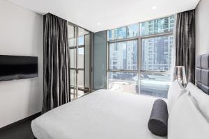 a hotel room with a bed and a window at Meriton Suites Chatswood in Sydney