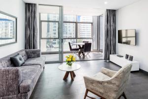 a living room with a couch and a table at Meriton Suites Chatswood in Sydney