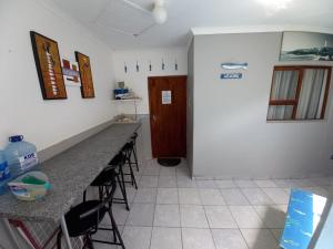 a kitchen with a row of bar stools and a door at Sunset Beach 34 in Margate