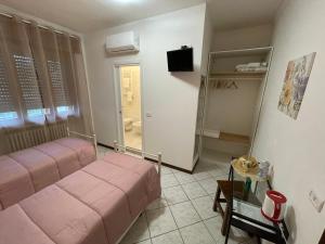 a small room with a bed and a television in it at Sole in Gattinara