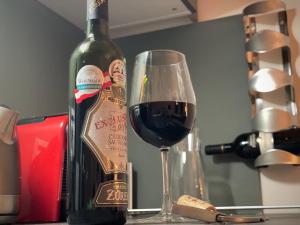 una copa de vino tinto junto a una botella de vino en Harfa Apartment 30 en Praga