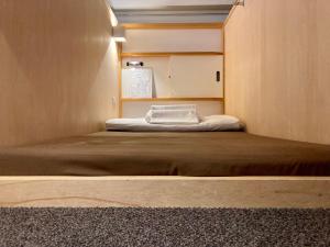 a small bedroom with a large bed in it at Santiago Guesthouse Kyoto in Kyoto