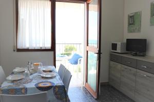 una sala da pranzo con tavolo e balcone di Luminous flat with frontal sea view - Beahost a Bibione