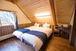 sypialnia z dużym łóżkiem w kabinie w obiekcie Kudo's Lodge w mieście Hakuba