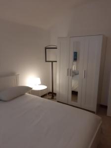 1 dormitorio con 1 cama blanca y armario blanco en Appartamento A.D., en Alessandria