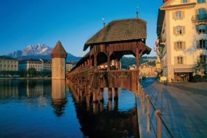uma ponte de madeira no meio de uma massa de água em Luzern Youth Hostel em Lucerna