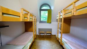 a room with three bunk beds and a window at Luzern Youth Hostel in Lucerne