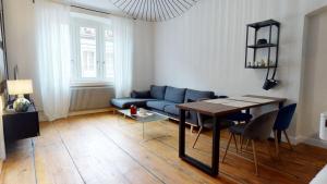 un salon avec un canapé bleu et une table dans l'établissement Le Neubau, à Colmar 21 autres photos