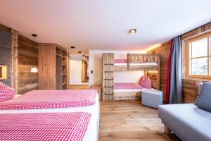 a bedroom with two bunk beds and a couch at Spielberghaus in Saalbach-Hinterglemm
