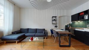 un salon avec un canapé bleu et une table dans l'établissement Le Neubau, à Colmar