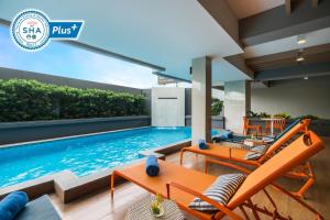 a swimming pool in a house with orange furniture at Alt Hotel Nana by UHG in Bangkok