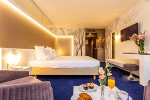 a hotel room with a bed and a living room at Grand Hotel Plovdiv in Plovdiv