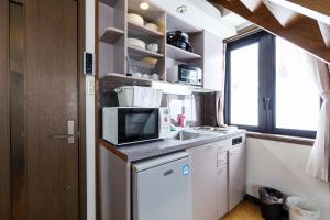 a small kitchen with a sink and a microwave at コンドミニアム白馬五竜 in Hakuba