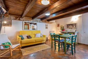 uma sala de estar com um sofá amarelo e uma mesa em Emerald Top in Old Town by sea em Alghero
