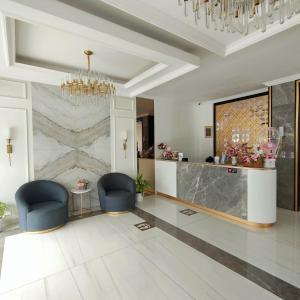 hol z dwoma niebieskimi krzesłami i kamienną ścianą w obiekcie Kala Hotel Semarang w mieście Jomblang +46 zdjęć