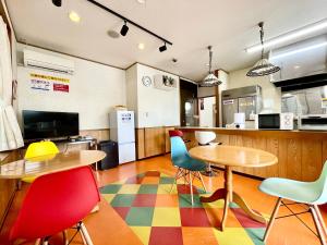 ein Zimmer mit 2 Tischen und Stühlen sowie einer Küche in der Unterkunft Time Rich in Okinawa