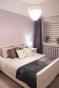 a bedroom with a large bed and a chandelier at Siauliai Apartments - Lieporiu in Šiauliai