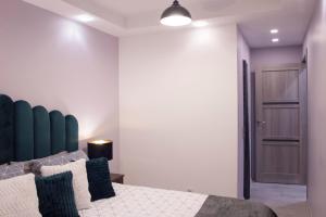 a bedroom with a bed with a blue headboard at Siauliai Apartments - Lieporiu in Šiauliai