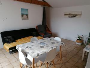 ein Esszimmer mit einem Tisch, Stühlen und einem Bett in der Unterkunft Chez pépé in Barbâtre