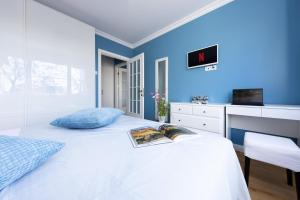 a bedroom with a white bed with a blue wall at Luxury Cosy Apartment Central- Unirii Square/Old Town Adela Accommodation in Bucharest