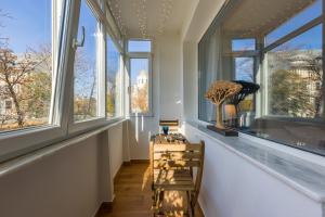 a room with windows and a table and chairs at Luxury Cosy Apartment Central- Unirii Square/Old Town Adela Accommodation in Bucharest