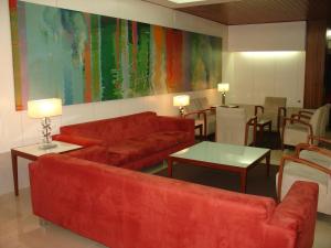 a living room with a red couch and a table at Hotel Eurosol Leiria & Jardim in Leiria