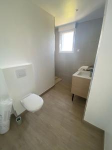a bathroom with a toilet and a sink at Bel appartement à 200m de la plage in Barneville-Carteret