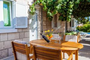 una mesa de madera con copas y una botella de vino en Green Garden House, en Korčula