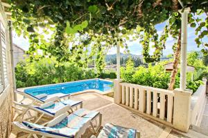 un patio con sillas y una piscina en Green Garden House, en Korčula