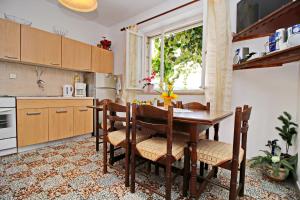 cocina con mesa con sillas y ventana en Green Garden House, en Korčula