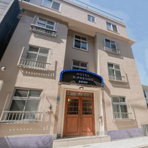 un bâtiment avec un hôtel et un panneau au-dessus de la porte dans l'établissement Hotel S-Presso Ebisu, à Osaka