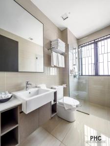 a bathroom with a sink and a toilet and a mirror at Hutton Central Hotel By PHC in George Town