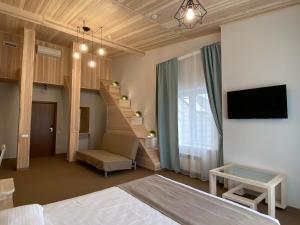 1 dormitorio con 1 cama y escalera con TV en Irbis Hotel, en Kazán