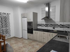 een keuken met een wastafel en een fornuis top oven bij Apartamento para familias in Marzagán