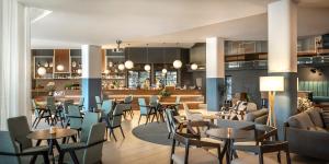 a restaurant with tables and chairs and a bar at Aminess Vival Maestral Hotel in Novigrad Istria