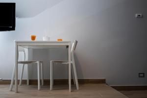einem weißen Tisch mit zwei Hockern und einem Tisch mit in der Unterkunft Dea Casa Vacanze in Salerno
