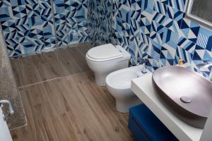 a blue and white bathroom with a toilet and a sink at Dea Casa Vacanze in Salerno