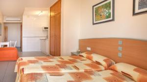 ベニドルムにあるEstudios RH Solのベッドとバスルーム付きのホテルルームです。